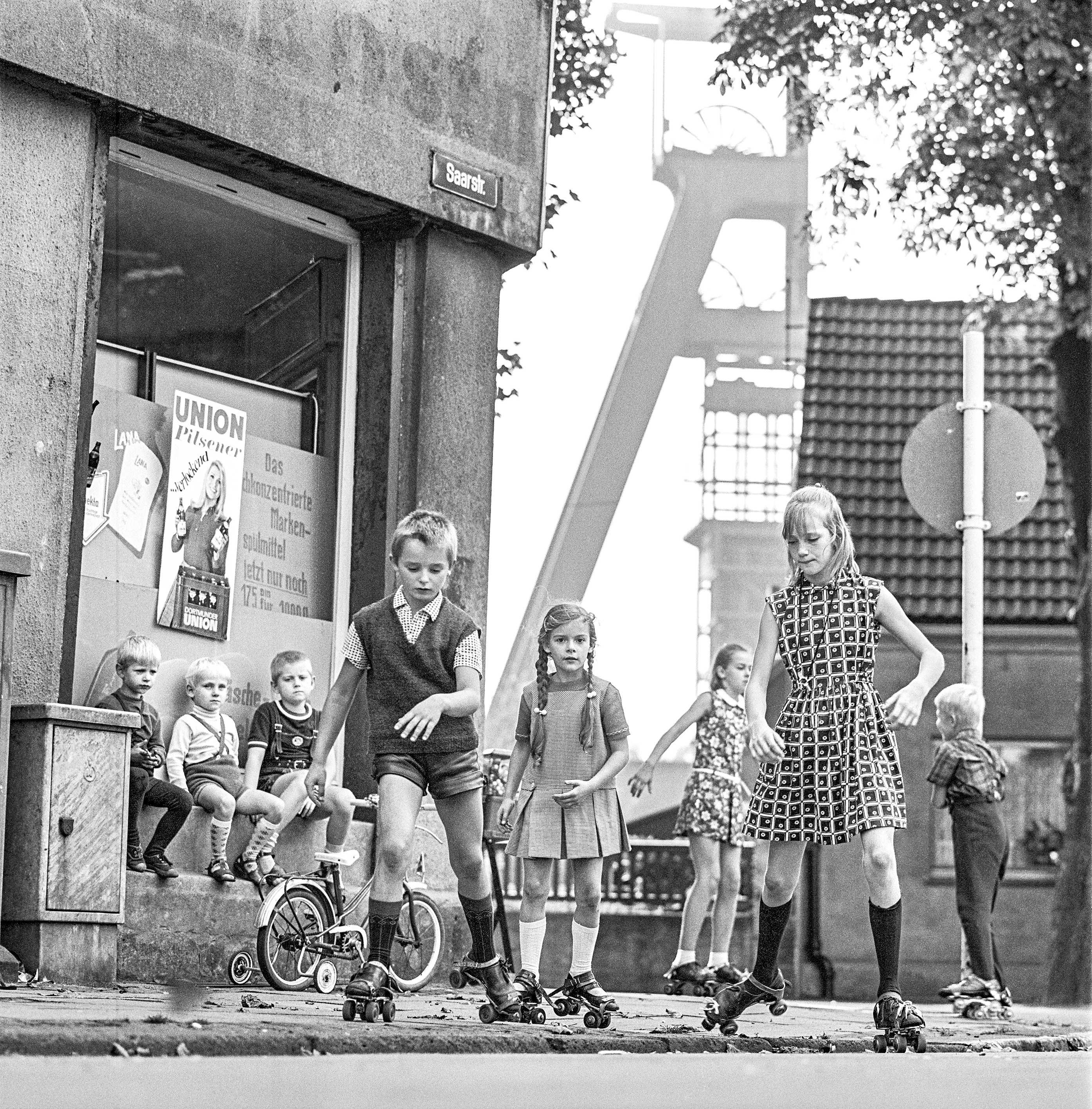 Fotografie von einer Gruppe Kindern, die mit Rollschuhen auf dem Gehweg fahren