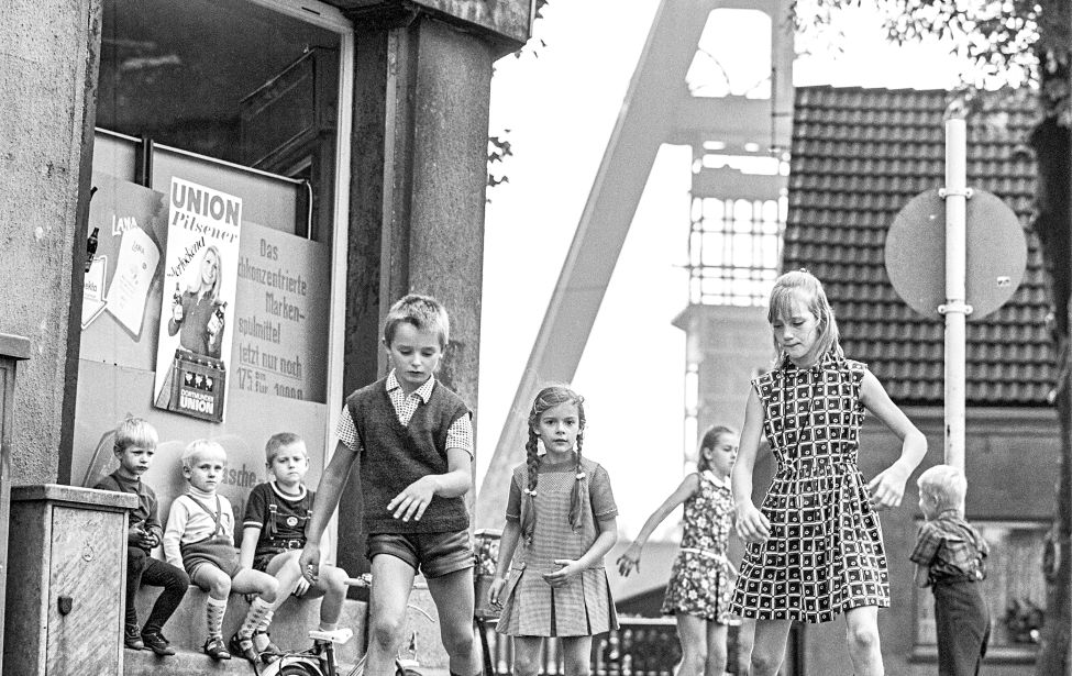 Fotografie von einer Gruppe Kindern, die mit Rollschuhen auf dem Gehweg fahren