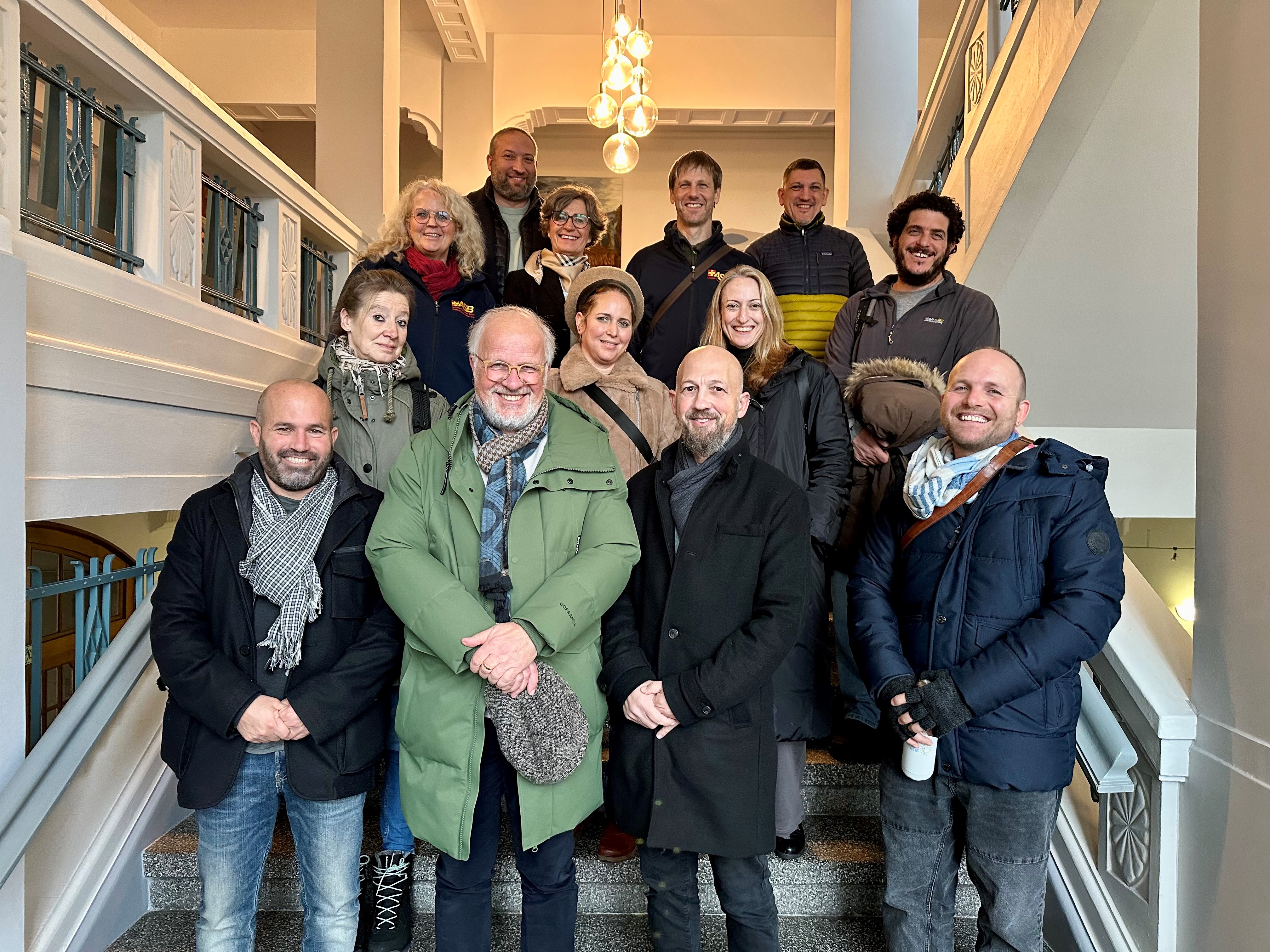 Gruppenportrait aller Beteiligten auf der Treppe im Rathaus