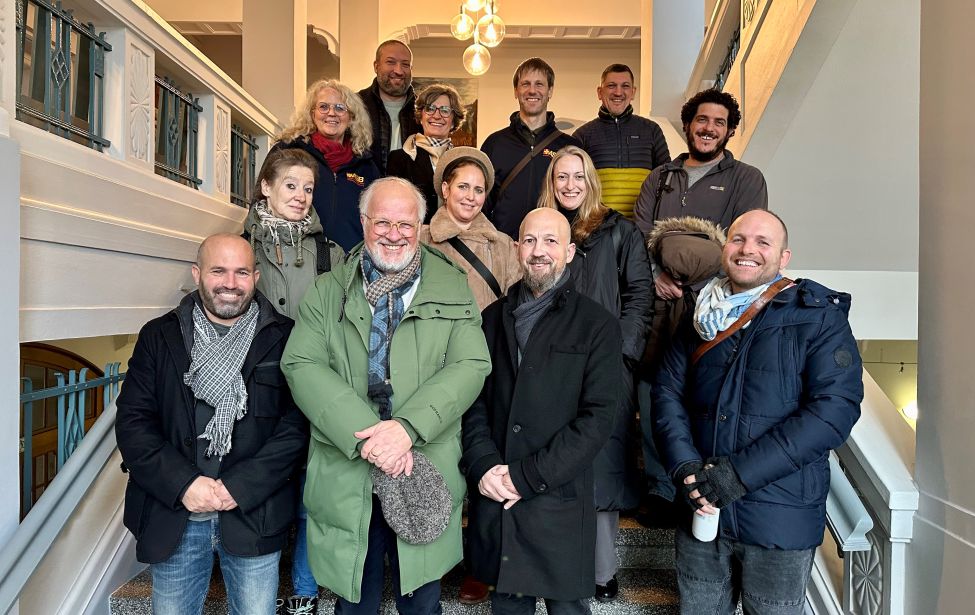 Gruppenportrait aller Beteiligten auf der Treppe im Rathaus