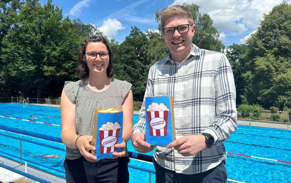 Svenja Breddemann, Klimaschutzmanagerin und Niels Vogel vom Referat Sport und Bewegung werben für das Open-Air-Kino im Freibad Welper.